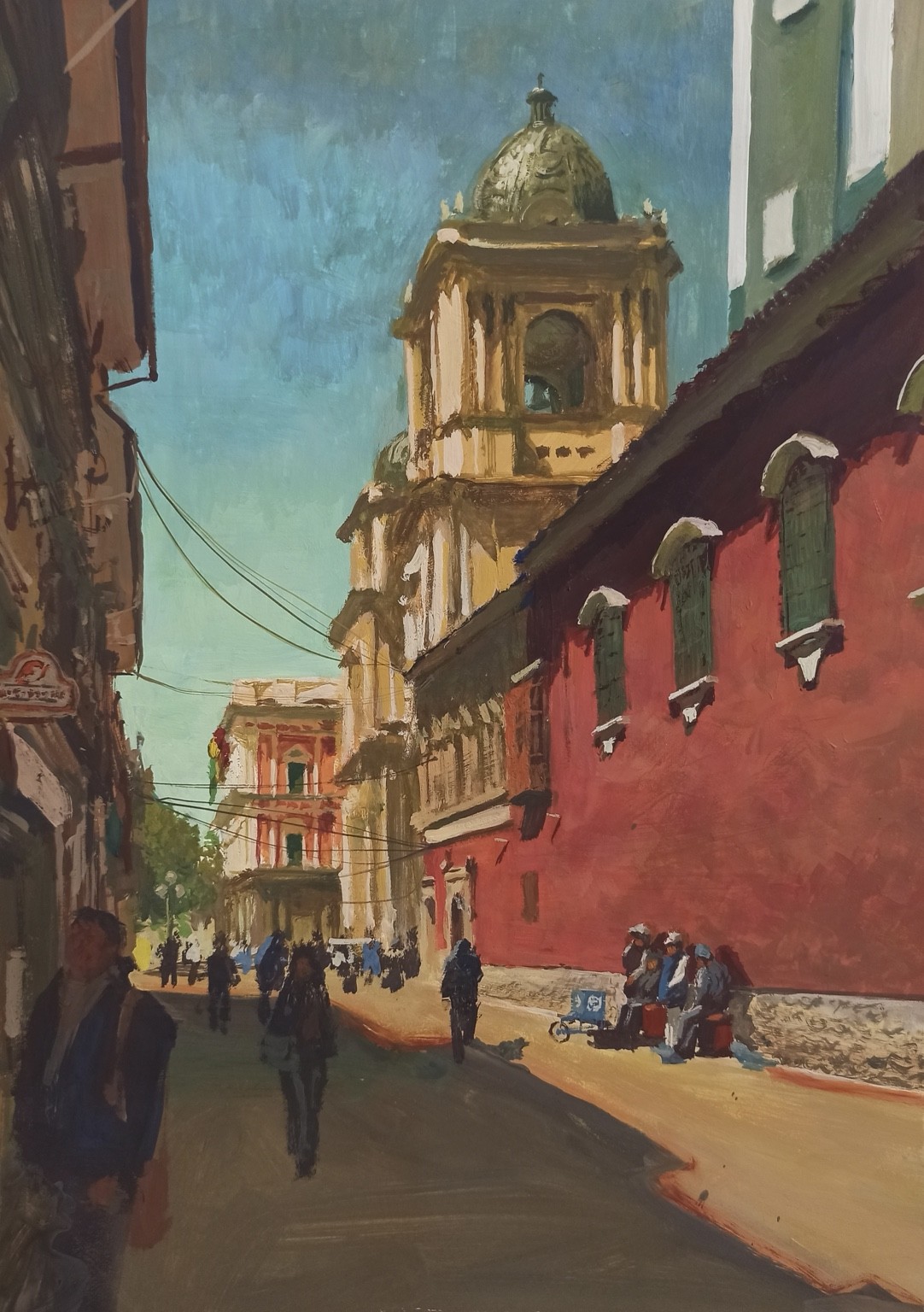 Calle Comercio con peatones, fachada roja y torre de iglesia